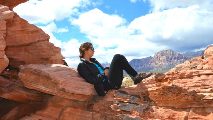 Woman sitting on rock in desert in daytime during a hike in Moab, UT.