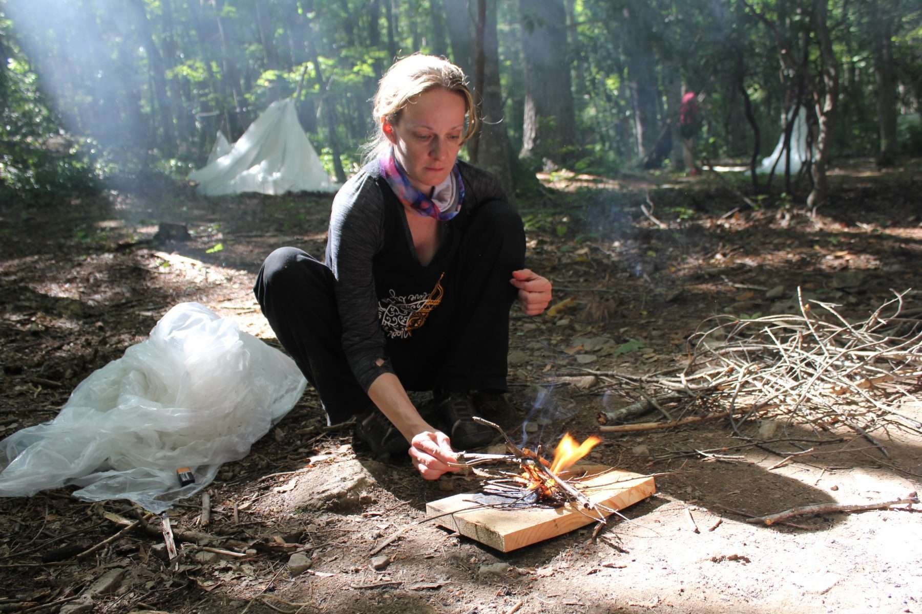 Woman learning how to start a camp fire during a survival training class in Cawtaba, Virginia