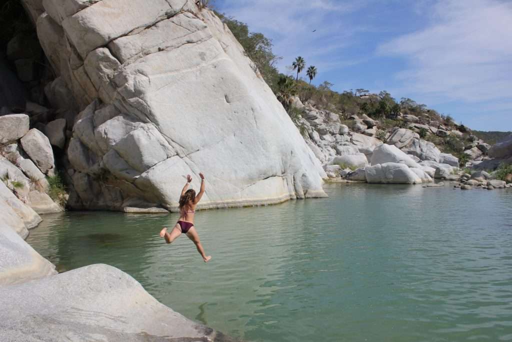 woman jumping into a lake
