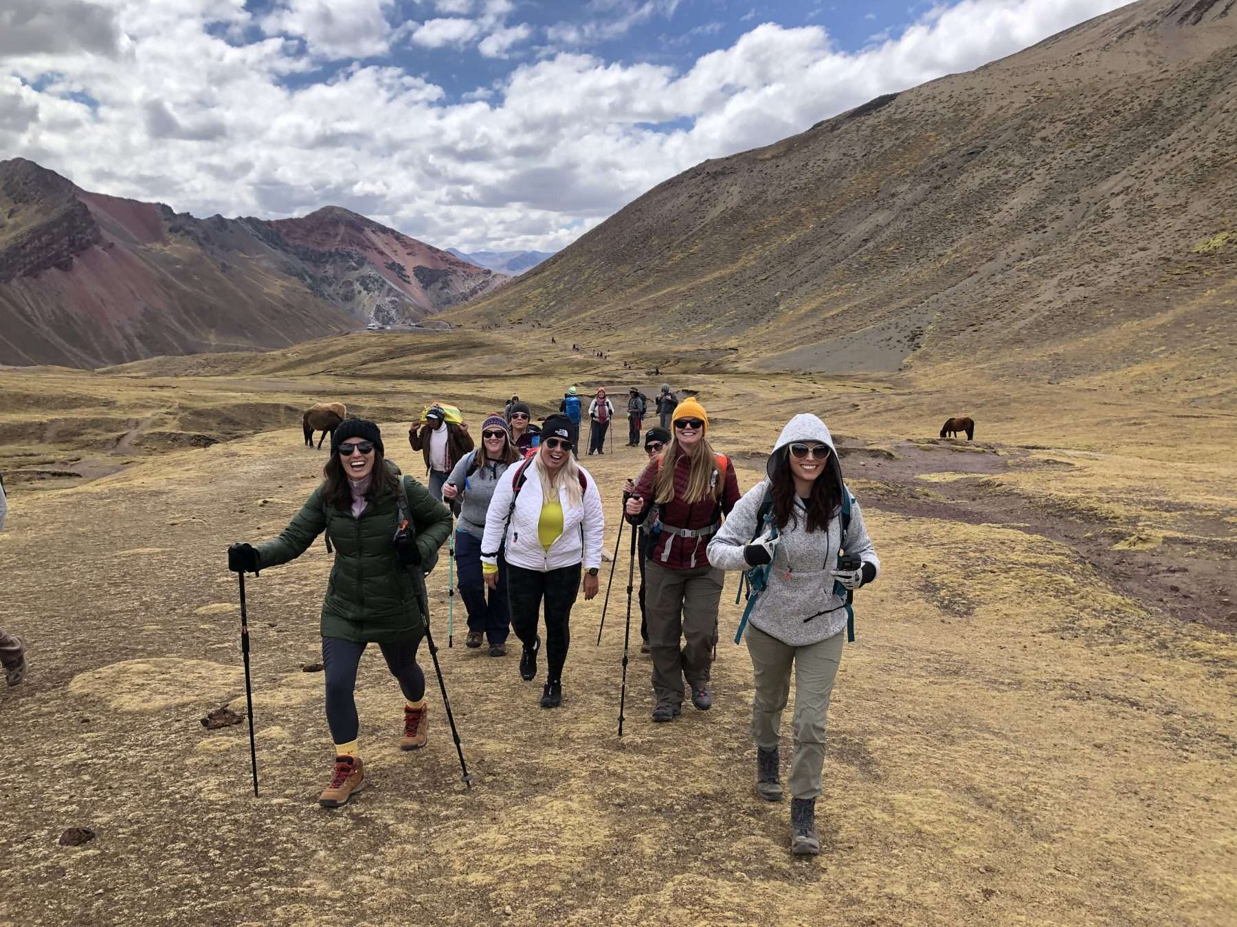 women hiking to rainbow mountain on a machu picchu adventure tour vacation