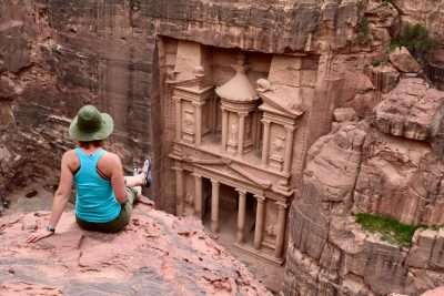 Woman sitting at a rock overlooking Petra in Jordan during a tour.