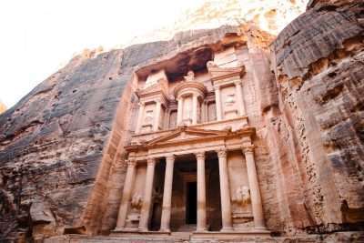 A building facade with columns carved into the side of a rock known as Petra