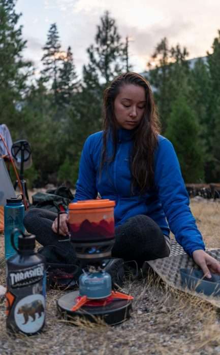 Woman cooking on a camp stove during a Yosemite Half Dome Hike and Backpacking Trip.